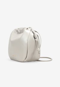 Bolso de cuero gris claro con cordón ajustable, de forma redondeada, textura suave y correa delgada ajustable. Presenta un discretamente logo en dorado.