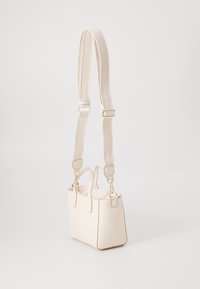 Piccola borsa a mano color crema realizzata in materiale sintetico, con forma strutturata, doppi manici superiori e una tracolla rimovibile con dettagli del logo.