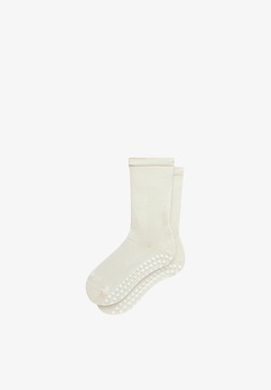Beige katoenen sokken met een getextureerd oppervlak en een anti-slip patroon van siliconen stippen op de zolen voor extra grip.
