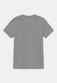 Camiseta gris de manga corta hecha de tela suave, con cuello redondo y sin patrones ni gráficos visibles en la parte de atrás.