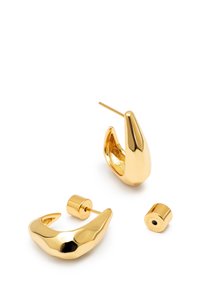 Boucles d'oreilles en forme d'anneau de couleur dorée avec un design lisse et courbé, doté d'une finition polie. Comprend un petit accent cylindrique amovible.