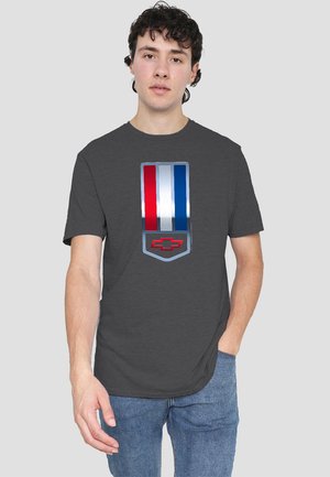 Gray t-shirt featuring a prominent Chevrolet emblem with red, white, and blue vertical stripes. Soft fabric, short sleeves, casual fit.
