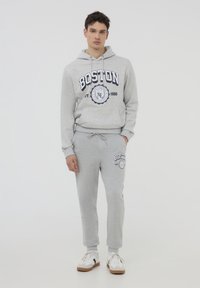 Set di felpa grigia con cappuccio e pantaloni della tuta con stampa grafica "BOSTON" in blu navy, realizzato in misto cotone, con cintura regolabile e polsini elastici.