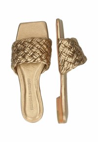 Sandali in oro con una parte superiore intrecciata e un design aperto e piatto. Finitura metallica liscia e suola in legno chiaro.