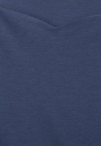 Tmavě modrá tkanina s hladkou strukturou, obsahující jemný V-tvarovaný šev nahoře. Rovnoměrná barva bez viditelných vzorů nebo akcentů.