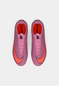 Un paio di scarpini da soccer Nike Mercurial rosa con un vivace swoosh arancione e interno rosso, visti dall'alto su sfondo bianco.