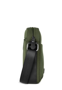 Borsa di stoffa verde oliva con una tracolla nera. Presenta una chiusura con zip, un design elegante e accessori in metallo. Ha una forma rettangolare.