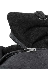 Kapuzenshirt mit einem schwarzen Außenmaterial mit weicher Textur, Innenfutter und einem Metallreißverschluss mit einer Zuglasche zum Schließen.