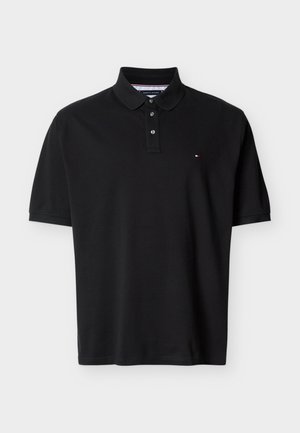 Must värviline lühikeste varrukatega polo särk, millel on kolm nuppu ja vasakul rinnal väike punane, valge ja sinine logo, valgel taustal.