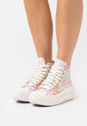 Hochschnittige Sneaker mit einem weißen Stoffobermaterial, das mehrfarbige Blumenmuster aufweist, und einer dicken weißen Gummisohle mit strukturierten Details.