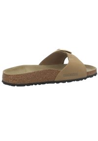 Une sandale Birkenstock simple couleur beige avec une semelle en liège, semelle noire et une large bride avec boucle en métal.
