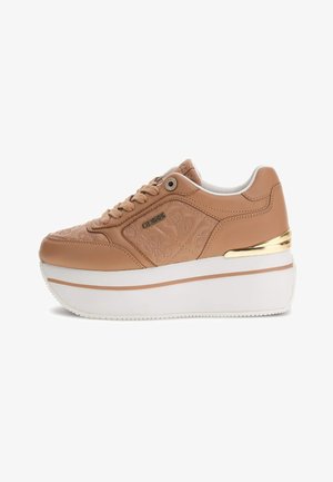 Beige platform sneaker met een bovenwerk van lakleer, een geborduurde uitstraling, gouden accenten en een witte rubberen zool.