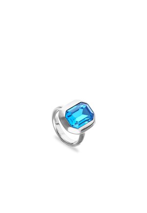 Anillo de plata con una gran piedra preciosa de corte rectangular de color azul brillante engastada en una montura de bisel sobre fondo blanco.