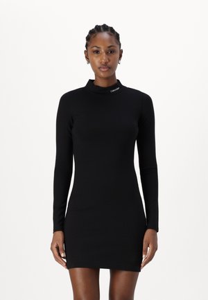 Abito lungo nero a maniche lunghe con colletto alto, realizzato in materiale elasticizzato. Presenta un logo sottile sul colletto e una silhouette aderente.