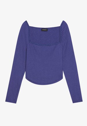 Violetti pitkähihaine paita, jossa on neliön muotoinen kaula-aukko, teksturoitu kangas ja hieman lyhennetty helma. Kaula-aukossa sinistä ommelta.