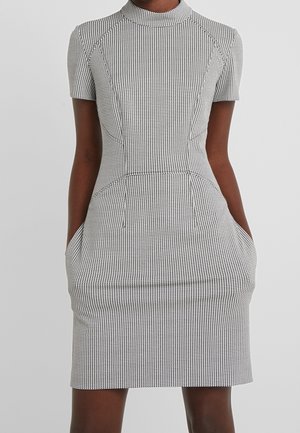 Robe ajustée à manches courtes avec col haut, motif petit pied-de-poule noir et blanc, et poches latérales.