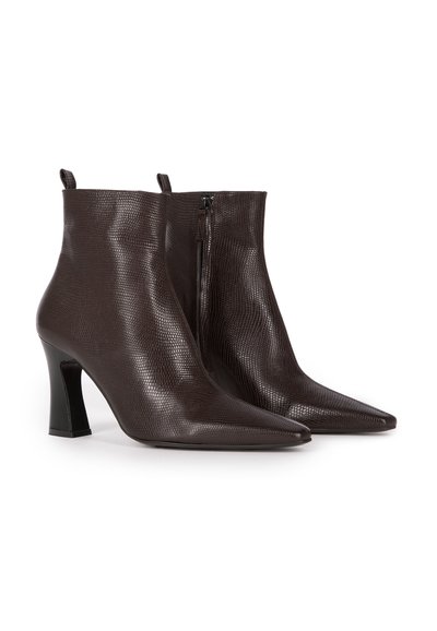 Brown leather ankle boots with a textured finish, pointed toe, and 3-inch tapered heel; features a side zipper and pull tabs.