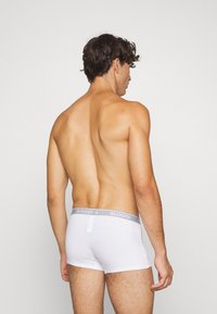 Weiße SLOGGI Boxershorts mit einem grauen Bund. Aus Baumwollmaterial, eng anliegendem Schnitt und mittellanger Beinform. Glatte Textur und minimale Details.