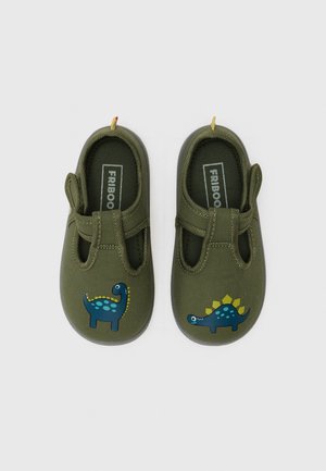 Chaussures pour enfants vert olive en tissu texturé doux, avec des appliqués de dinosaures bleus sur les bouts des chaussures et une sangle élastique pour un enfilage facile.