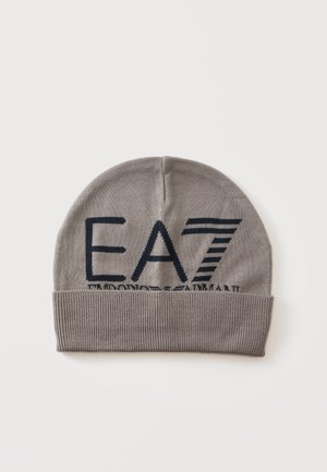 Grå strikket hue med ombukket kant med stort sort EA7 Emporio Armani logo foran mod en ensfarvet baggrund.