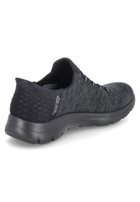 Schwarzer Sportschuh mit strukturiertem Obermaterial, featuring eine glatte Ferse und flexible Sohle. Die Schnürsenkel sind in das Design integriert, um einen sicheren Sitz zu gewährleisten.