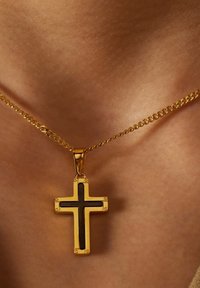 Gouden ketting met een gouden kruis hanger met een zwarte accent, textuur oppervlak en kleine hardwaredetails.