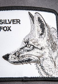 Gestickter Patch mit dem Profil eines Silberfuchses, grau und weiße Fäden auf einem weißen Hintergrund mit schwarzem Rand. Der Text lautet "SILBERFUCHS."