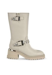 Bota de cuero beige hasta la rodilla con hebilla plateada brillante y acentos de rhinestone, tacón grueso con suela texturizada, acabado suave.