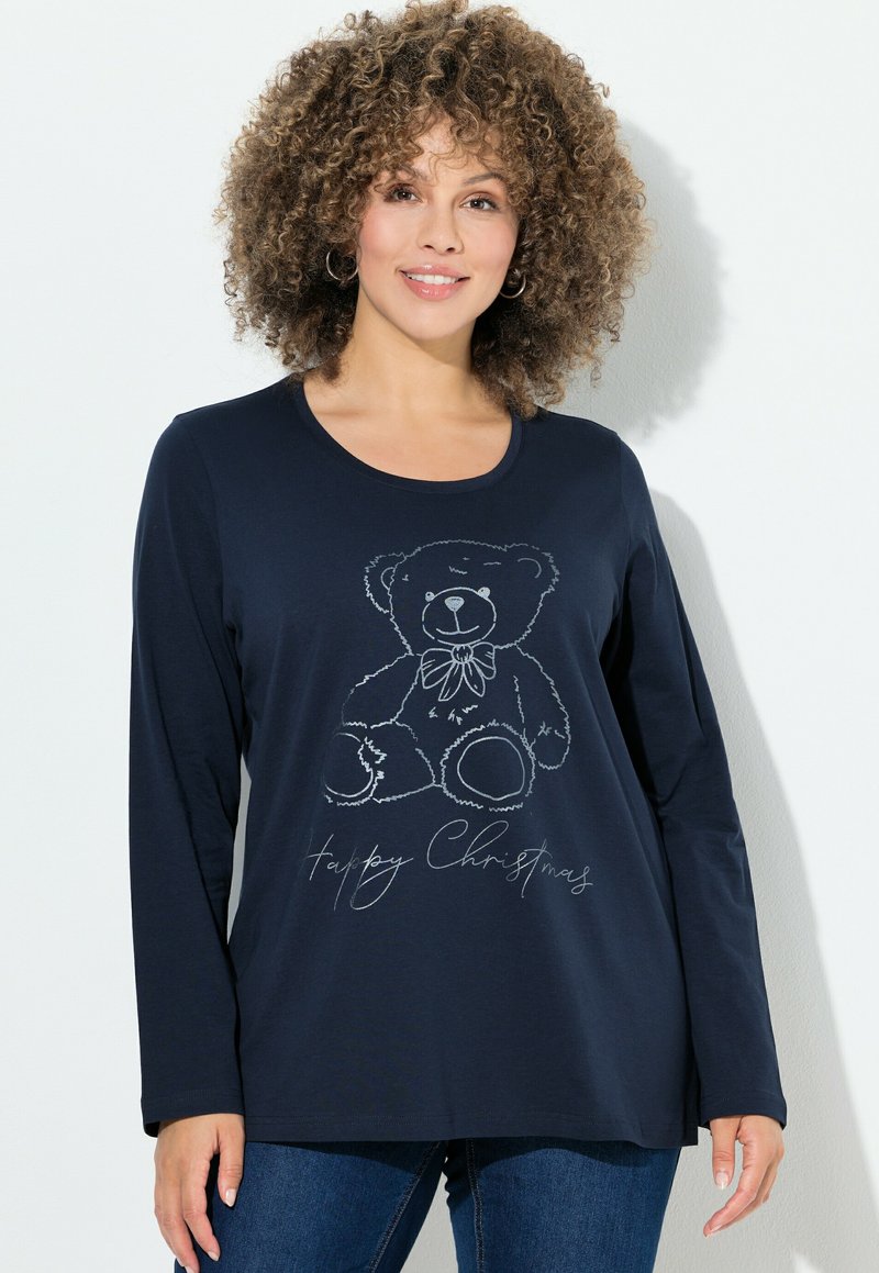 T-shirt a maniche lunghe di colore blu navy con una sagoma argento di un orsetto con un fiocco, testo stampato "Buon Natale" sotto. Tessuto morbido, vestibilità casual.