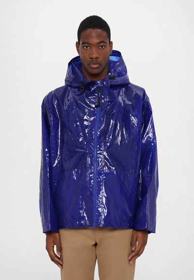 Blue glossy rain jacket with a hood, featuring a front zipper, elastic cuffs, and a relaxed fit. Smooth texture and minimal design accents.