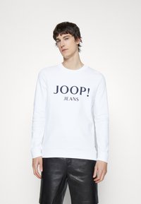 Felpa bianca con testo "JOOP! JEANS" in blu scuro. Design classico con scollo rotondo, maniche lunghe e polsini e orlo a coste.