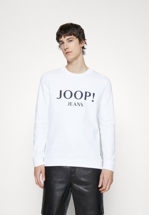 White sweatshirt featuring dark blue "JOOP! JEANS" text. Classic crewneck design, long sleeves, and ribbed cuffs and hem.