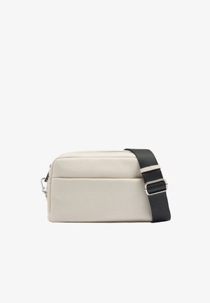 Torebka na ramię z jasnobeżowej, fakturowanej skóry. Wyposażona w czarny, regulowany pasek oraz zamek błyskawiczny, o gładkim, smukłym kształcie.