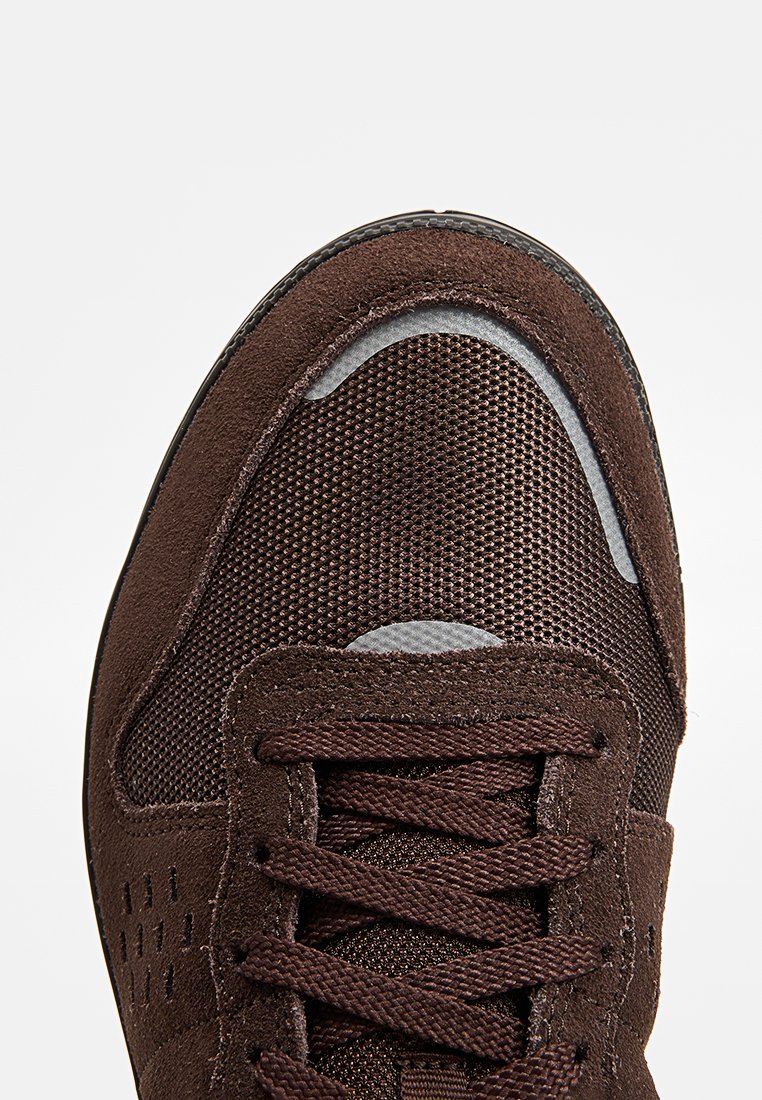 Basket en cuir marron avec un dessus en maille, des accents en daim, un bout rond et des lacets plats. Semelle extérieure en caoutchouc avec des détails texturés.