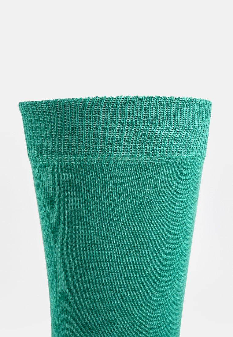 Skarpeta do kolan w zielonym kolorze, wykonana z miękkiego, elastycznego materiału z ryflowaną teksturą i elastycznym mankietem na górze.