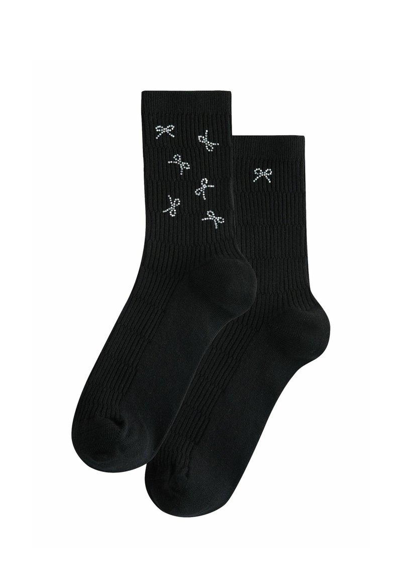 Schwarze Knöchelsocken mit gerippter Textur, die auf dem oberen Abschnitt verstreute silberne Rippendesigns aufweisen.