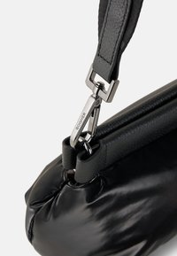 Borsa nera caratterizzata da un materiale morbido e lucido con una trama trapuntata, dotata di una clip in tonalità argento e di una tracolla piatta.