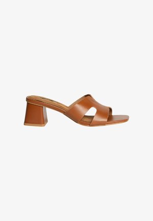 Sandal de tacón cuadrado de cuero marrón con diseño de punta abierta. Dos tiras cruzadas crean un patrón recortado en la parte superior. Plantilla texturada.