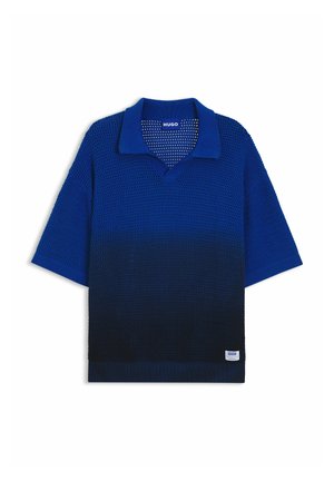 Polo en maille bleu manches courtes avec un dégradé du bleu royal au bleu marine foncé, col ouvert et petite étiquette blanche de marque près de l’ourlet.