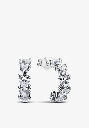 Orecchini in argento con un design a forma di cuore decorati con numerosi gioielli trasparenti e sfaccettati. Ogni orecchino presenta una disposizione a cascata di pietre.