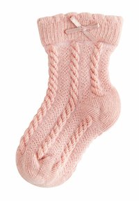 Calzino rosa lavorato a maglia con un motivo a treccia testurizzato, polsino arricciato e un piccolo fiocco di raso sul lato. Tessuto morbido con un aspetto accogliente.
