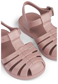 Różowe gumowe sandały z otwartymi palcami, wyposażone w poziome i pionowe paski, paski na kostkę oraz fakturowaną wkładkę.