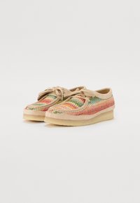 Chaussures en tissu tissé coloré avec une semelle en caoutchouc beige, forme arrondie et lacets assortis. Dessus texturé avec des motifs multicolores.