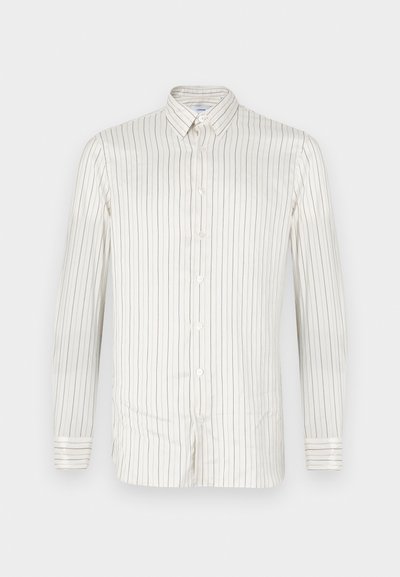 Camisa blanca de botones con estrechas rayas verticales en beige. Presenta un cuello puntiagudo, mangas largas y puños abotonados. Textura suave.