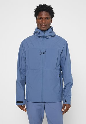 Niebieska wodoodporna kurtka z kapturem, z dwiema kieszeniami na piersi, zapięciem na zamek, teksturowanym materiałem i regulowanymi mankietami.