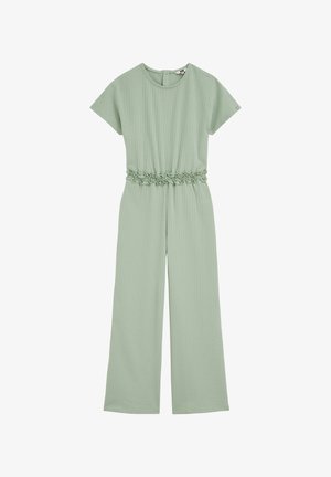Gaiši zaļš īss piedurkņu kombinezons ar plašām kājām un volānu elastīgu jostasvietu, teksturētu audumu un aizmugurējo pogu aizdari.