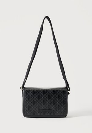 Sac bandoulière noir avec sangle réglable et motif géométrique subtil sur le rabat avant, présenté sur fond blanc.