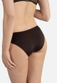 Sous-vêtements marron taille haute en tissu lisse et extensible. Présentent un design sans couture avec un joli élastique à la taille.