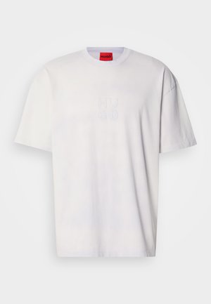 White cotton t-shirt featuring a crew neckline, dropped shoulders, and an embossed "HUGO" logo on the front. Smooth texture, relaxed fit.