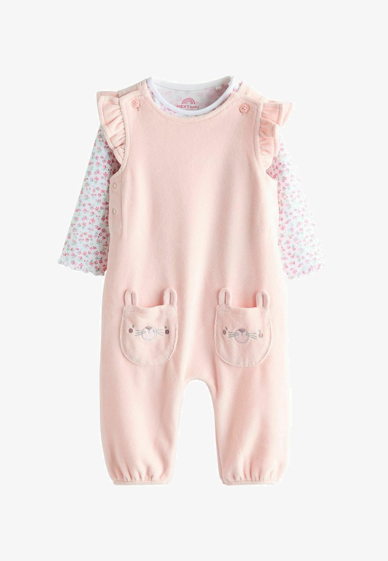 Rosa Fleece-Overall mit Rüschensämen, darunter ein langärmliges Shirt mit Blumenmuster. Taschen in Form von Hasengesichtern sorgen für Details. Weiche Textur.